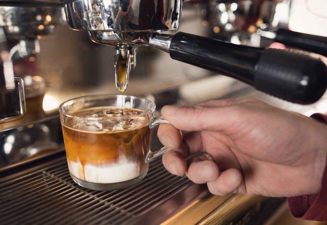 A person pouring a coffee into a cup